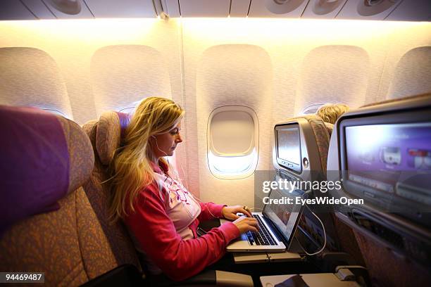 Woman is working with a notebook on board of a Emirates Airline passenger jet on December 08, 2009 in Trivandrum, India. Since some month its new...