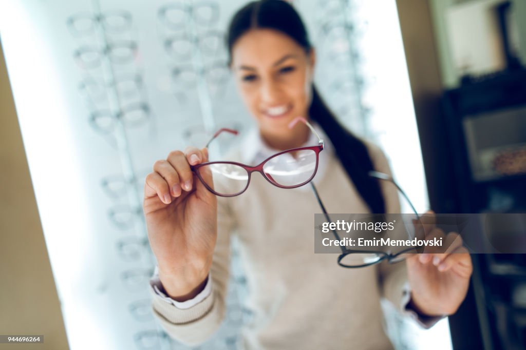 Donna che seleziona gli occhiali in un negozio di ottica