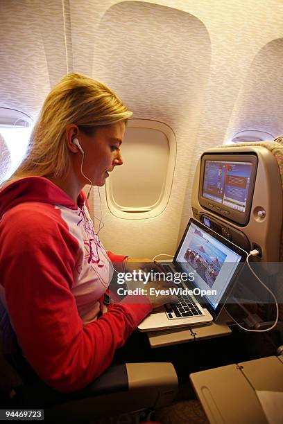 Woman is working with a notebook and listen to music with headphones on board of a Emirates Airline passenger jet on December 08, 2009 in Trivandrum,...