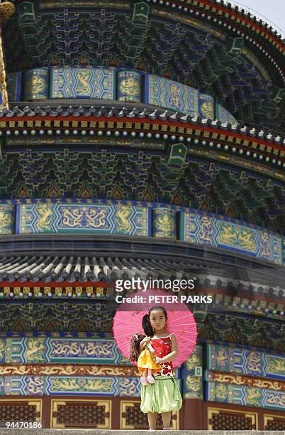 Young girl clutches her doll whilst visiting the Temple of Heaven in Beijing 29 May 2007. More than 20 percent of toys made in China for its domestic...