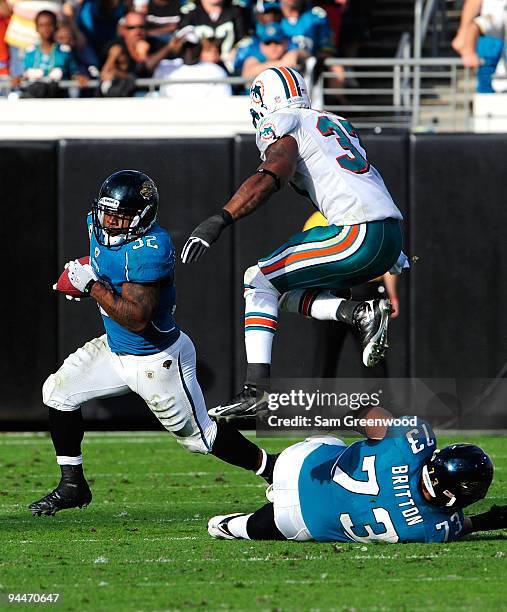 Yeremiah Bell of the Miami Dolphins attempts to tackle Maurice Jones-Drew of the Jacksonville Jaguars during the game at Jacksonville Municipal...