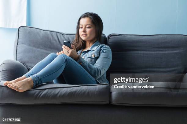 portrait of a casually-dressed, mixed-race lady texting - vandervelden stock pictures, royalty-free photos & images