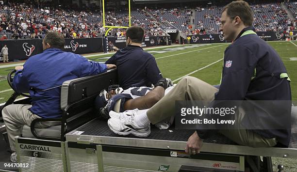 Linebacker Aaron Curry of the Seattle Seahawks is carted off the field after being injured in the fourth quarter of te game against the Houston...