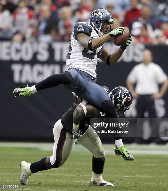 Wide receiver T.J. Houshmandzadeh of the Seattle Seahawks is upended by strong safety Dominique Barber of the Seatle Seahawks as he attempts to make...