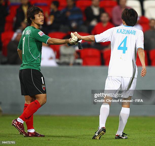 Goalkeeper Shin Hwa Yong of Pohang Steelers leaves the picth after receiving a red card and gives his gloves away to Kazunari Okayama of Pohang...