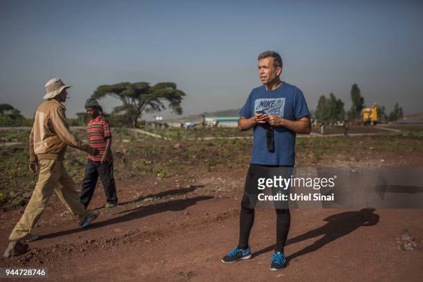 Professor Yannis Pitsiladis waits for Kenenisa Bekele at the finishline during a training at a highway under construction on September 26, 2015. In...