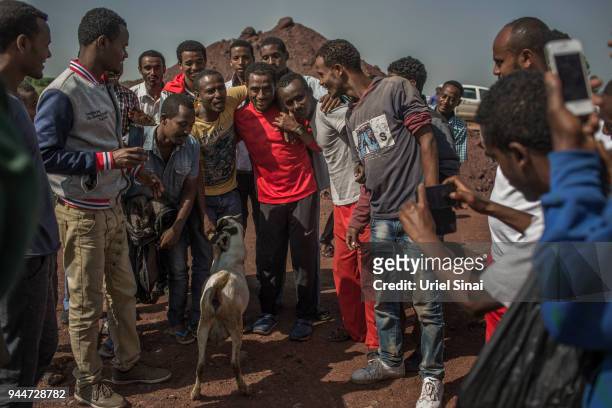 Locals get their picture taken with Kenenisa Bekele after his a training section at a highway under construction on September 26, 2015. In Kalite,...
