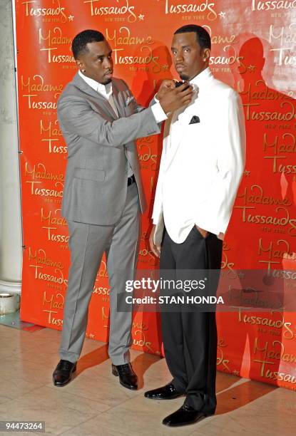 Sean "Diddy" Combs adjusts the bow tie on his wax likeness unveiled December 15, 2009 at Madame Tussauds New York wax museum. AFP PHOTO/Stan Honda
