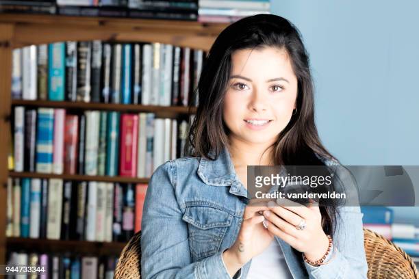 portrait of a cute, mixed-race lady texting - vandervelden stock pictures, royalty-free photos & images