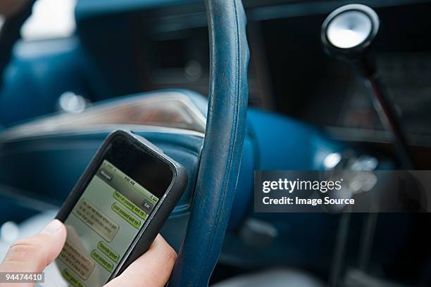 person driving and using cellphone - distracted driving stock pictures, royalty-free photos & images