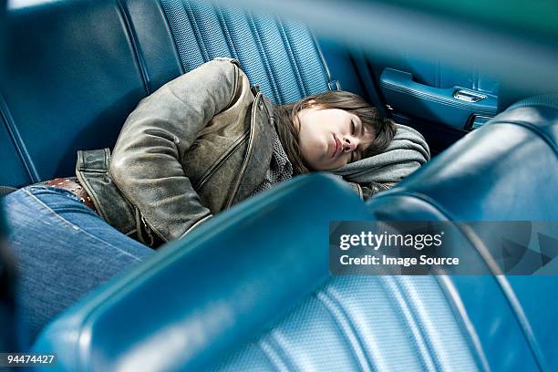 young woman asleep in car - sleeping in car stockfoto's en -beelden