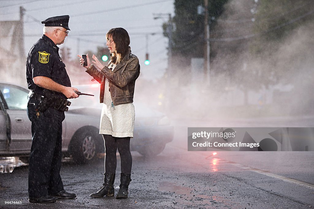 Young woman and police officer at scene of crash