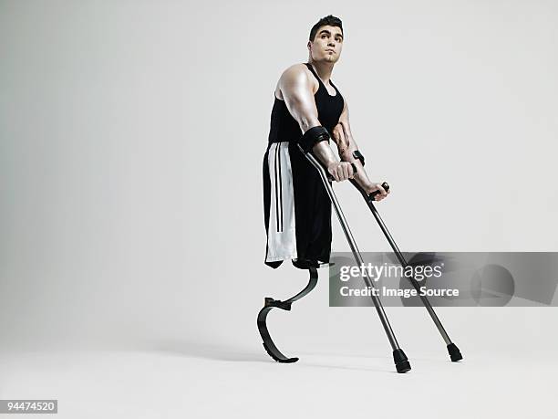 man with crutches and prosthetic leg - prosthetic equipment stock pictures, royalty-free photos & images