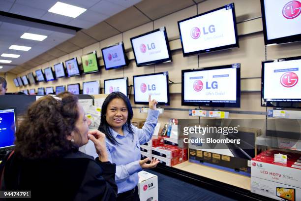Tara Talaue helps customer Sandra Rodriguez, left, shop for a television inside a Best Buy store in New York, U.S., on Tuesday, Dec. 15, 2009. Best...