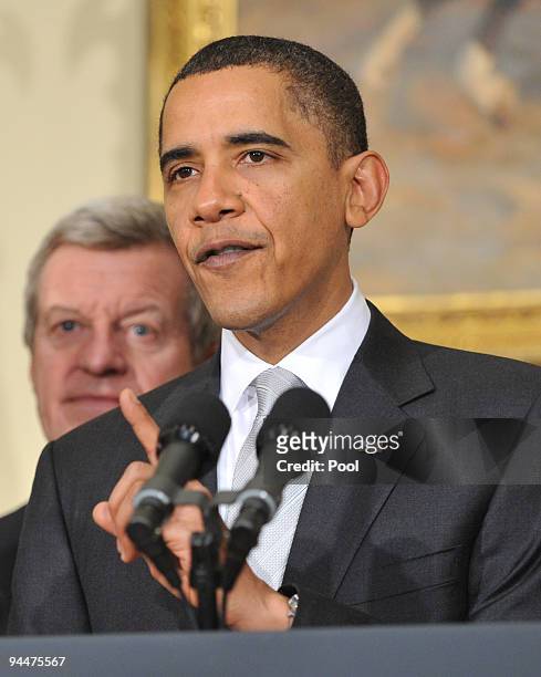 President Barack Obama speaks to the press as Sen. Max Baucus listens in the Roosevelt Room in the Eisenhower Executive Office Building on December...