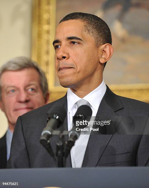 President Barack Obama speaks to the press as Sen. Max Baucus listens in the Roosevelt Room in the Eisenhower Executive Office Building on December...