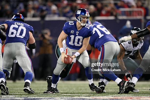 Eli Manning of the New York Giants looks to pass against the Philadelphia Eagles at Giants Stadium on December 13, 2009 in East Rutherford, New...