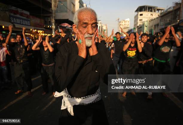 Shiite Muslim worshippers self-flagellate as they walk from central Baghdad towards the Iraqi capitals northern district of Kadhimiya on April 11...