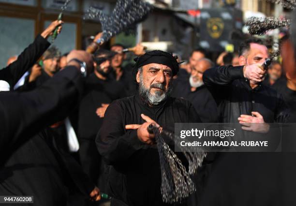 Shiite Muslim worshippers self-flagellate as they walk from central Baghdad towards the Iraqi capitals northern district of Kadhimiya on April 11...