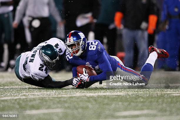 Mario Manningham of the New York Giants is tackled by Sheldon Brown of the Philadelphia Eagles at Giants Stadium on December 13, 2009 in East...