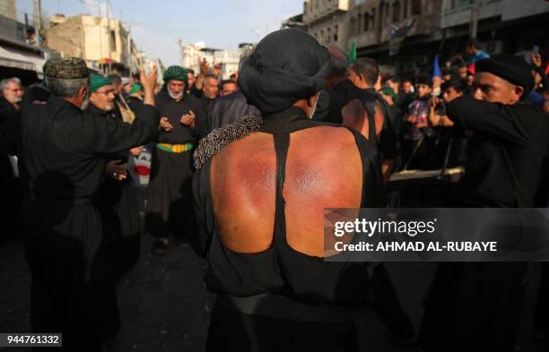 Shiite Muslim worshippers self-flagellate as they walk from central Baghdad towards the Iraqi capitals northern district of Kadhimiya on April 11...