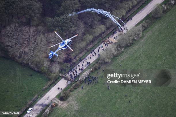 An aerial view shows a gendarmerie helicopter hovering over as gendarmes launch tear gas canisters at protesters on April 11 during a police...