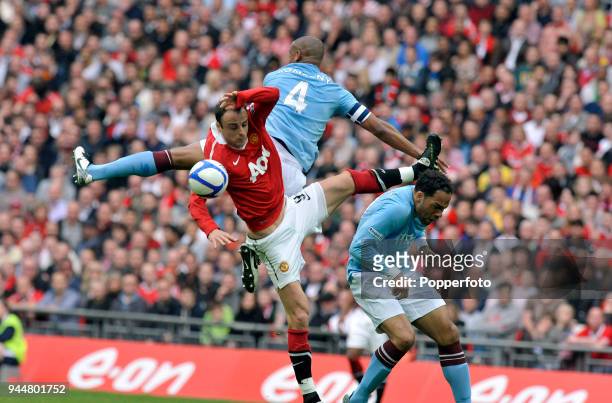 Vincent Kompany and Joleon Lescott of Manchester City clash with Dimitar Berbatov of Manchester United during the FA Cup sponsored by E.ON semi final...