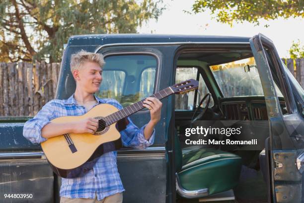 teen boy playing guitar,  leaning on  pick up truck - guitar pick stock pictures, royalty-free photos & images