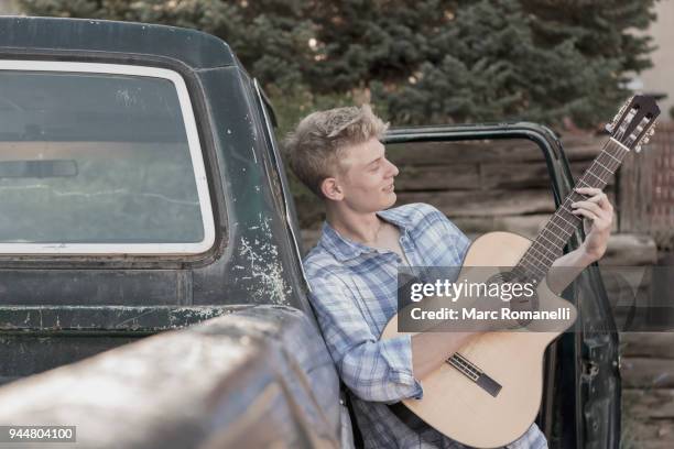 teen boy playing guitar,  leaning on  pick up truck - guitar pick stock pictures, royalty-free photos & images