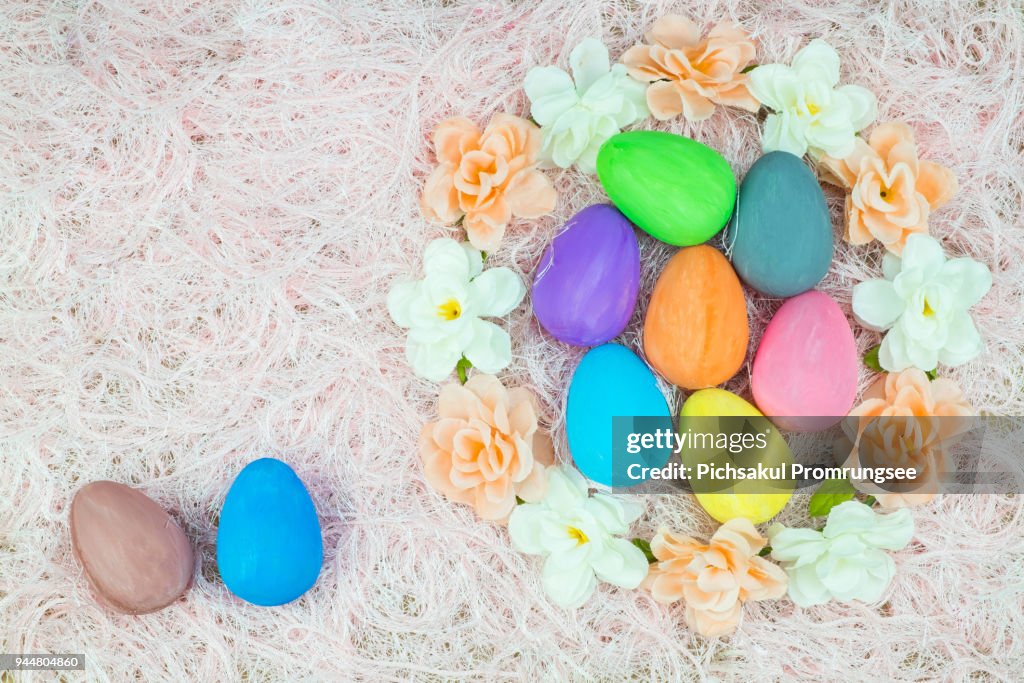 Vista de ángulo alto de coloridos huevos de Pascua con flores en la alfombra