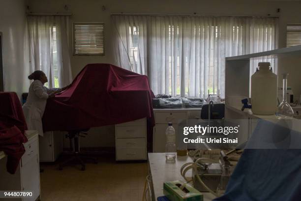 Laboratorian covers a biomedical laboratory equipment as it sits unplugged at the Addis Ababa university, on September 25, 2015. In Addis Ababa,...