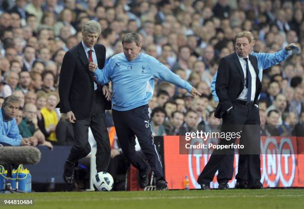 Arsenal manager Arsene Wenger is beaten to the ball by Tottenham Hotspur assistant coach Clive Allen during the Barclays Premier League match between...