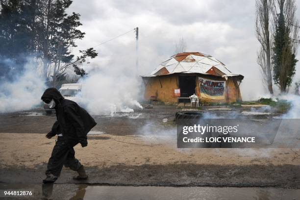 Protesters walks past smoke from tear gas canisters on April 11 during a police operation to raze the decade-old anti-capitalist camp known as ZAD...