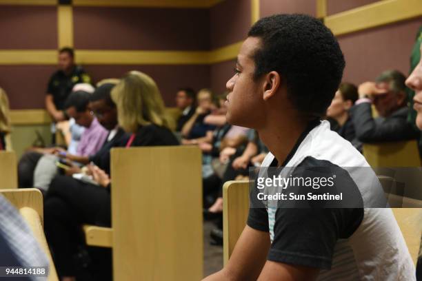 Nikolas Cruz's brother Zachary Cruz looks at his brother while sitting in the gallery in court before the beginning of a hearing in front of Broward...