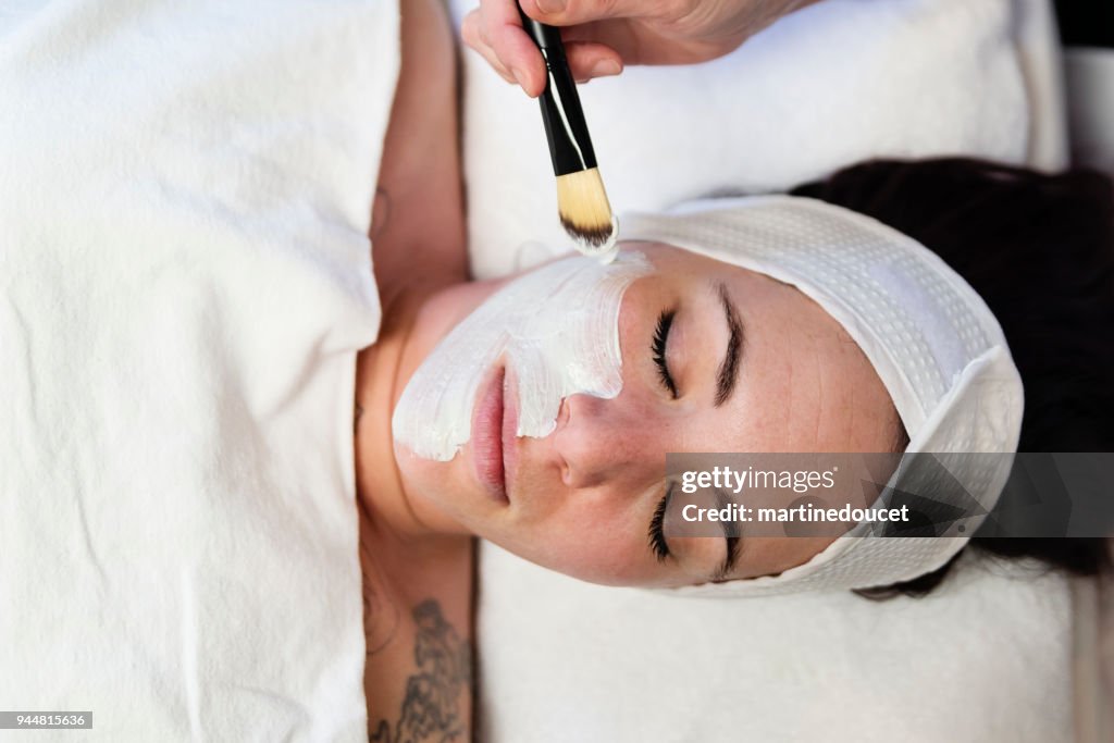 Joven recibe un tratamiento facial en el spa de belleza.