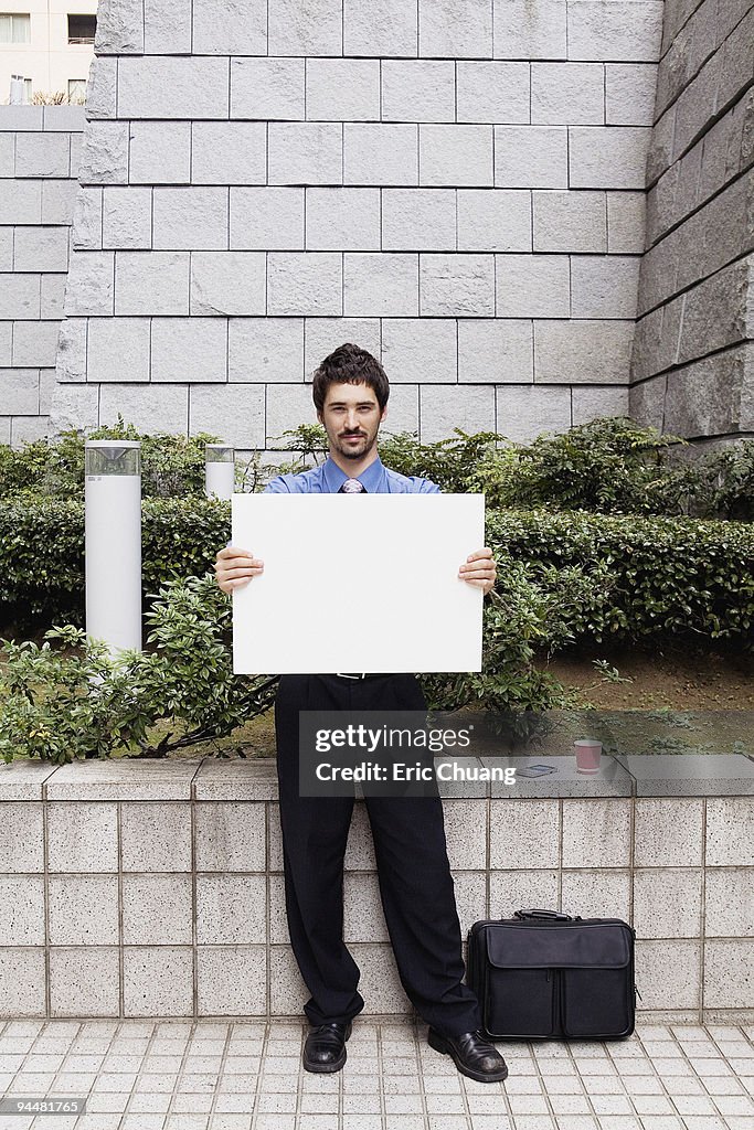 Businessman holding sign