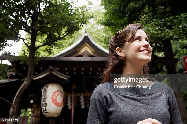 smiling woman standing in front of building, japan - japan tourism stock pictures, royalty-free photos & images