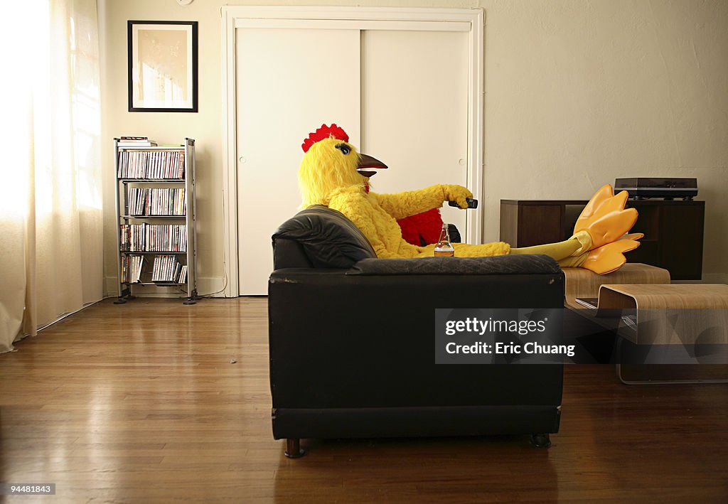 Person in chicken costume relaxing at home