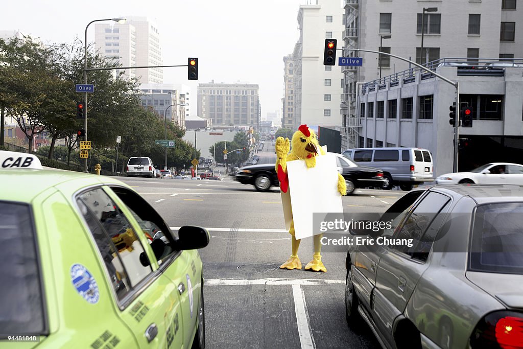 Person in chicken costume at crosswalk