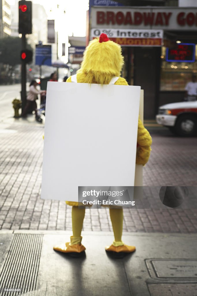 Person in chicken costume with sandwich board advertisement