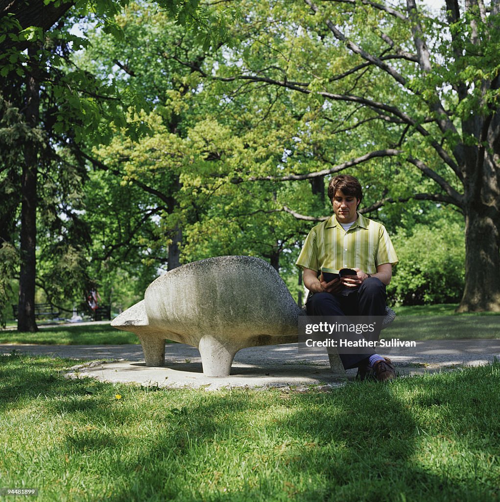 Man reading book in park