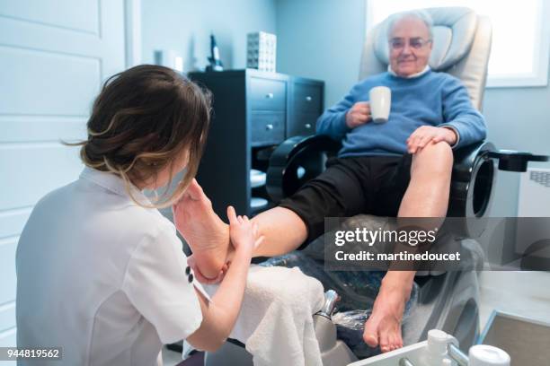 uomo anziano che ha una pedicure in un centro benessere di bellezza. - pedicure foto e immagini stock