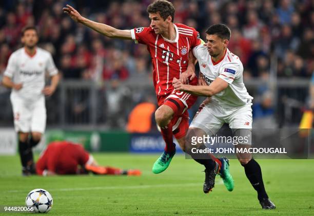 Bayern Munich's German forward Thomas Mueller and Sevilla's French defender Clement Lenglet vie for the ball during the UEFA Champions League...