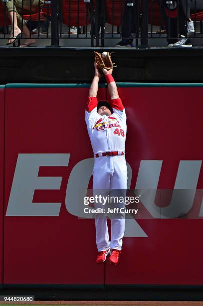 Harrison Bader of the St. Louis Cardinals leaps at the wall but is unable to catch a solo home run hit by Eric Thames of the Milwaukee Brewers during...