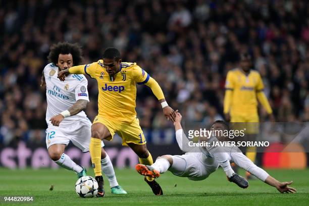 Juventus' Brazilian forward Douglas Costa vies with Real Madrid's Brazilian defender Marcelo and Real Madrid's Brazilian midfielder Casemiro during...