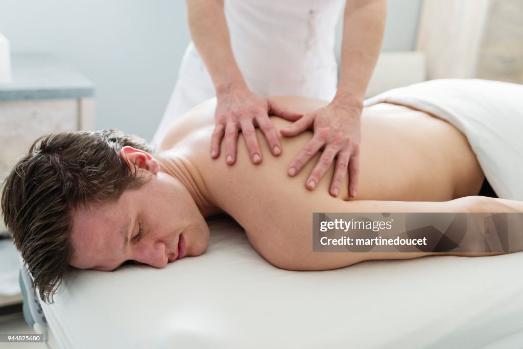 Massaggio alla schiena al giovane in beauty spa.