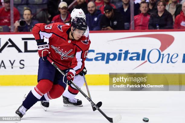 Jakub Vrana of the Washington Capitals controls the puck against Erik Karlsson of the Ottawa Senators in the first period at Capital One Arena on...