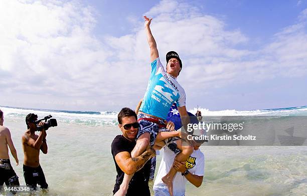 Taj Burrow of Australia claims his Billabong Pipeline Masters victory as he is chaired out of the water by coach Johnny Gannon of Australia and Mick...