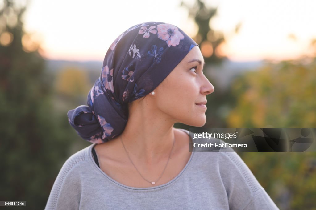 Woman battling cancer stands outside and contemplates her life