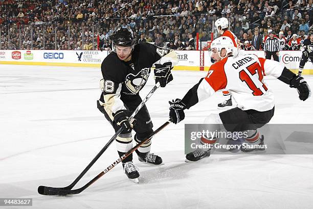 Tyler Kennedy of the Pittsburgh Penguins controls the puck in front of Jeff Carter of the Philadelphia Flyers on December 15, 2009 at Mellon Arena in...